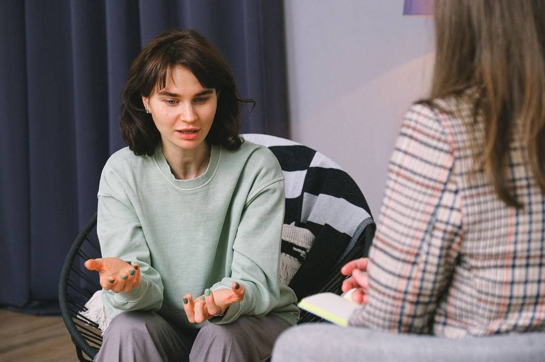 Two women sitting together in a calm, private coaching conversation