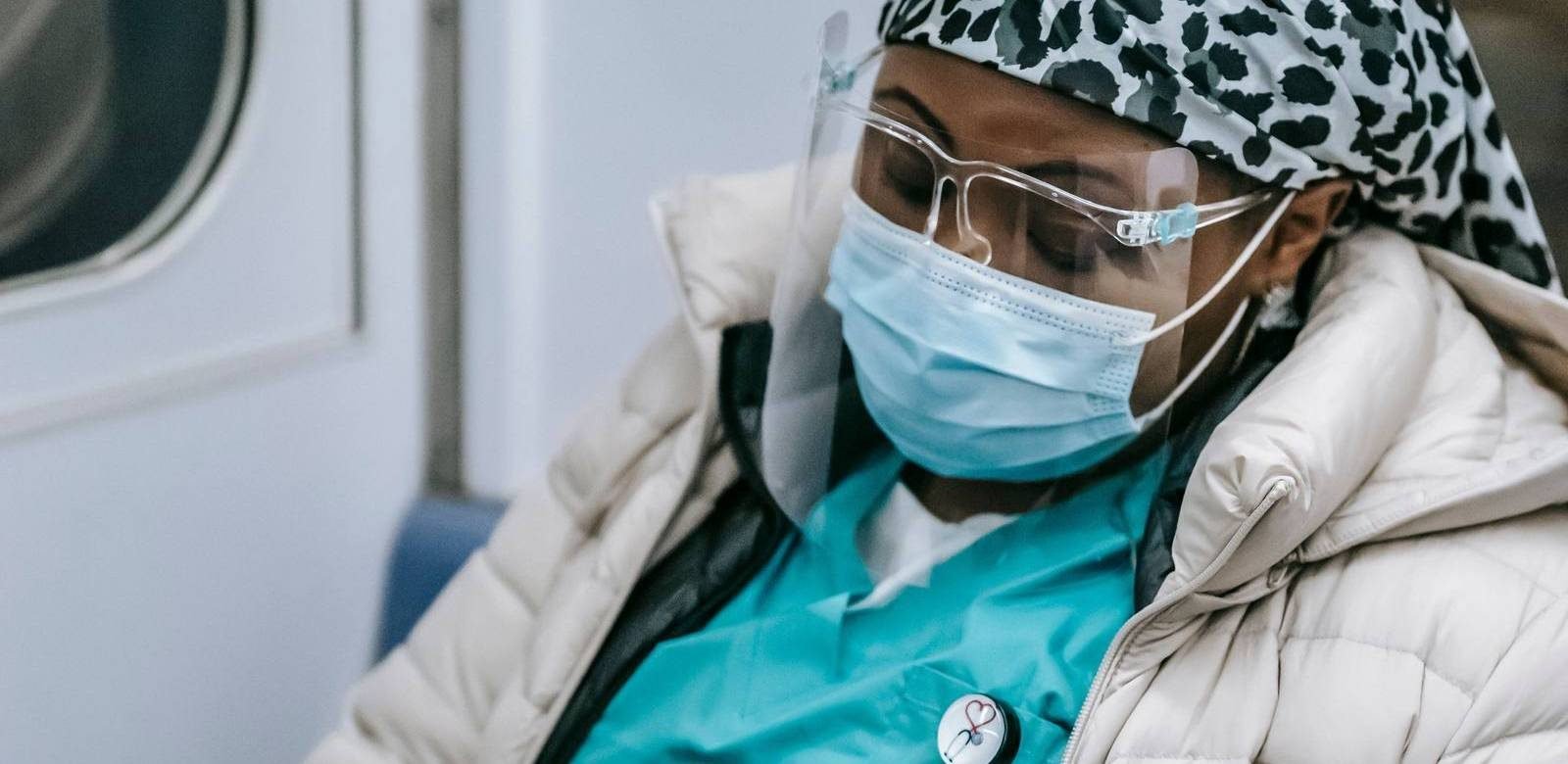 A nurse resting on her commute home after a long shift