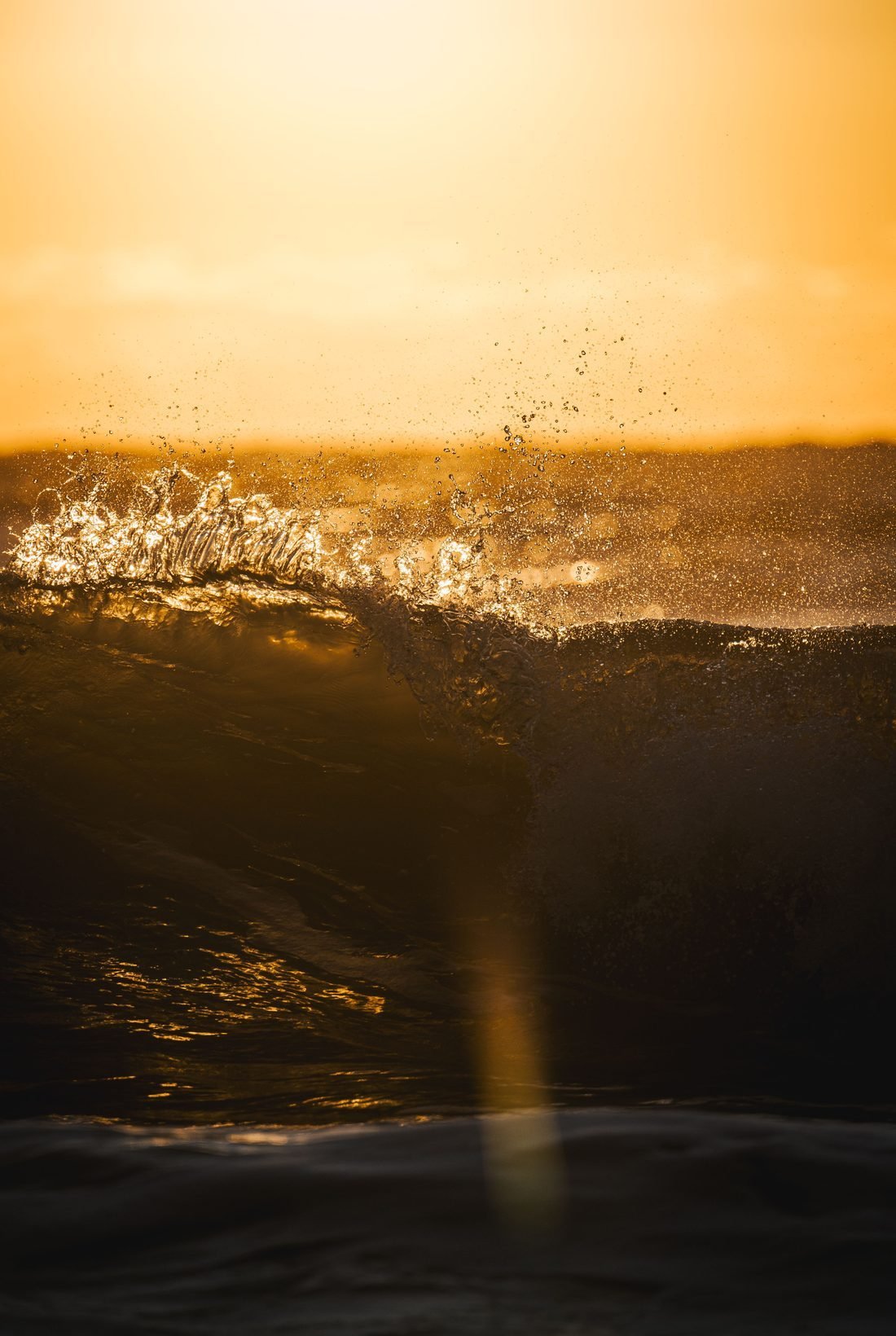 Golden light breaking over the water at sunrise